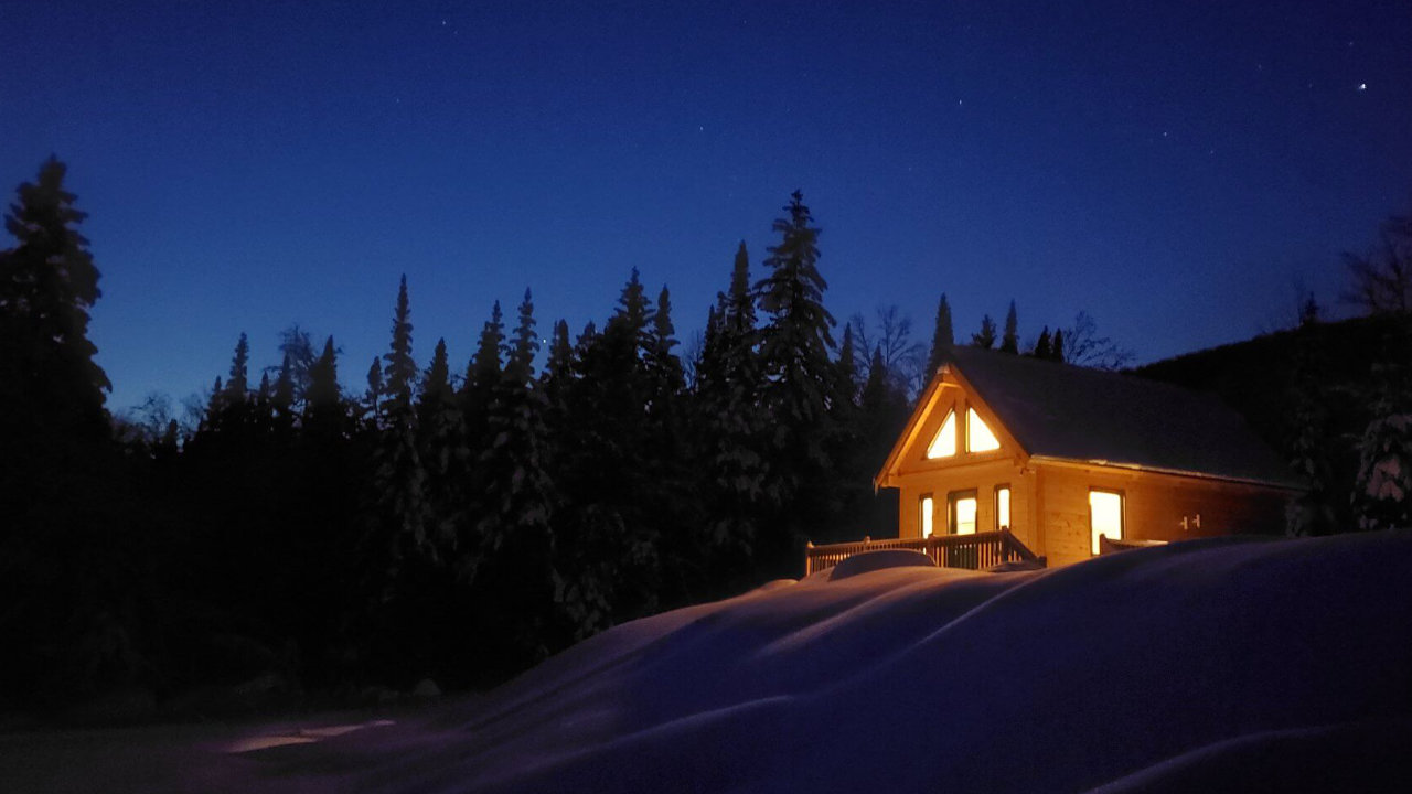 vue d'un chalet éclairé, une nuit d'hiver dans la ZEC Bas-St-Laurent